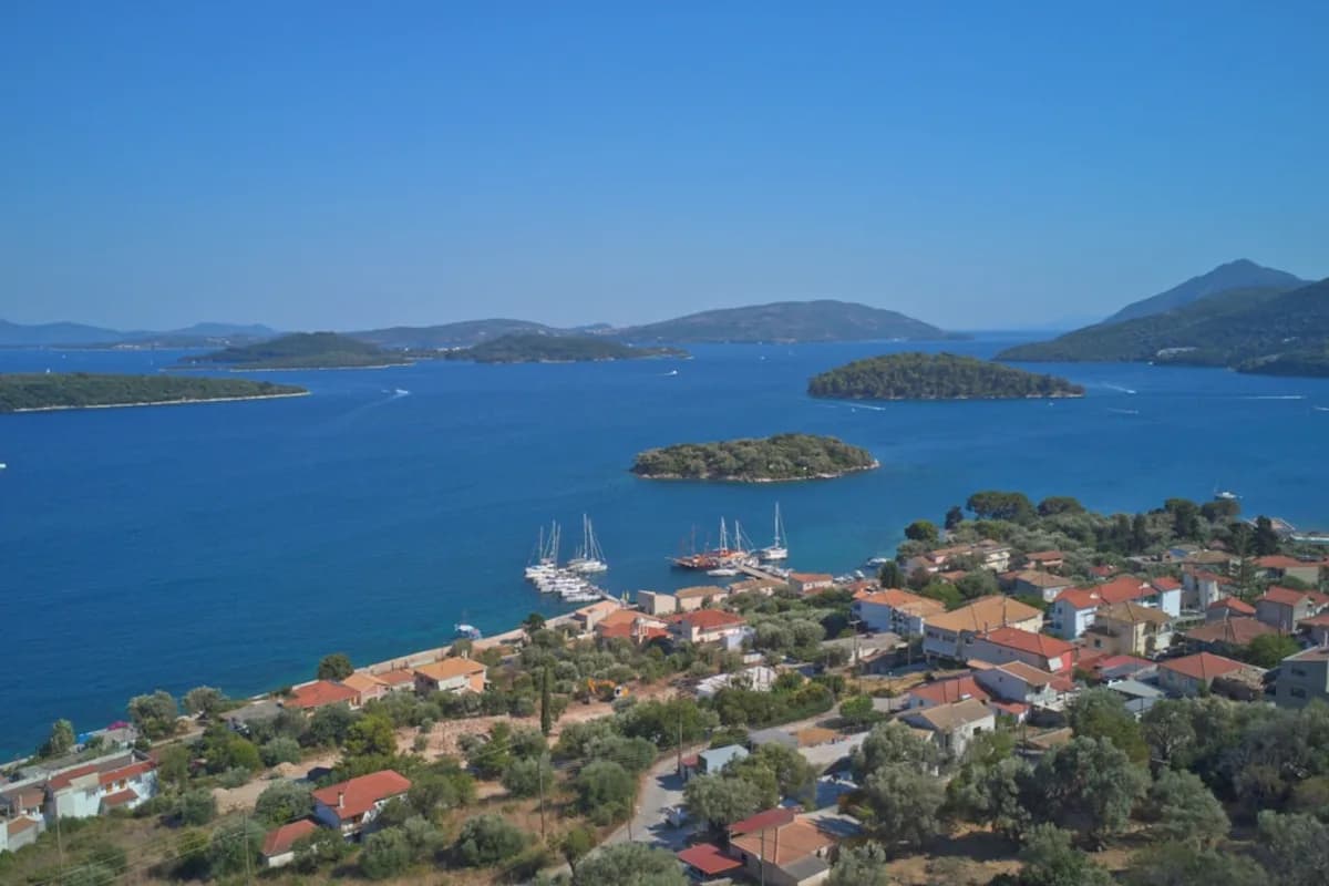 Grieks kustdorpje met zeilboten afgemeerd in een baai met turquoise water